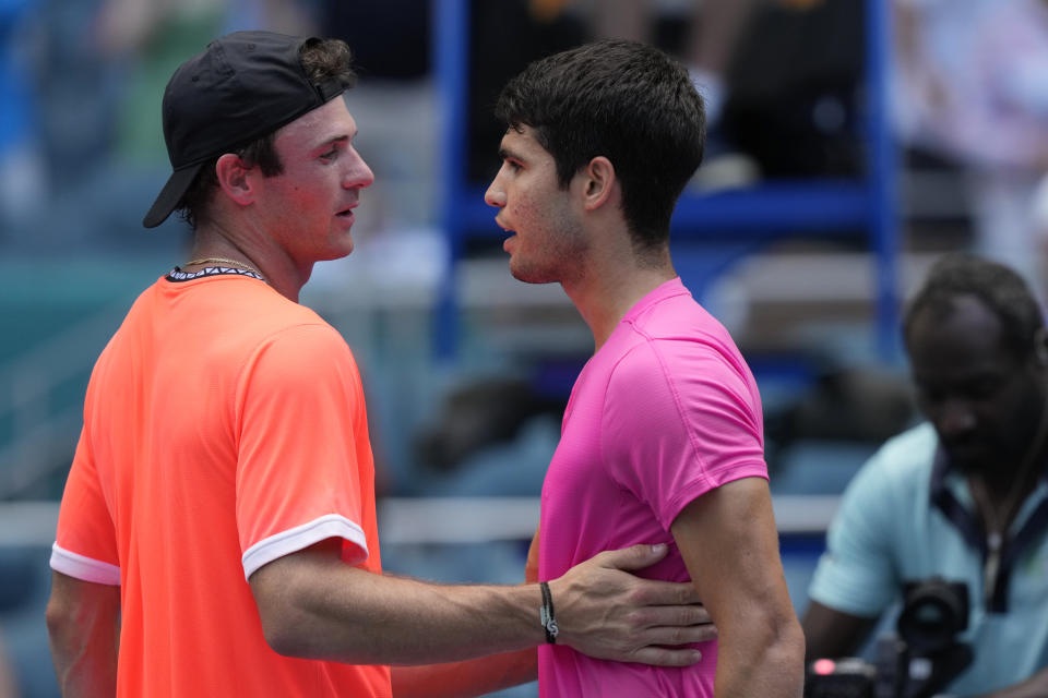 Tommy Paul and Carlos Alcaraz of Spain meet a the net at the end of a match at the Miami Open tennis tournament, Tuesday, March 28, 2023, in Miami Gardens, Fla. (AP Photo/Marta Lavandier)