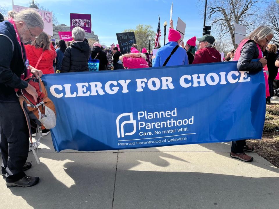 Two demonstrators hold a banner that reads, “Clergy for Choice.