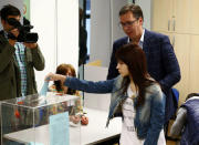 Milica Vucic, daughter of Serbian Prime Minister and presidential candidate Aleksandar Vucic (behind), places his ballot into the ballot box at a polling station during the presidential election in Belgrade, Serbia, April 2, 2017. REUTERS/Antonio Bronic