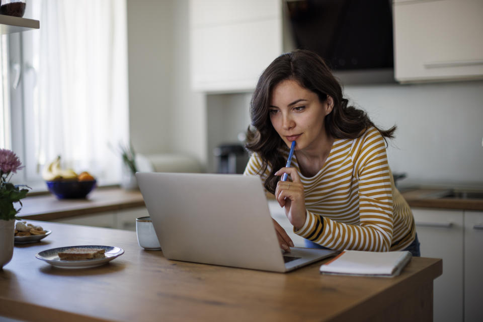 Young woman using a laptop while working from home savings