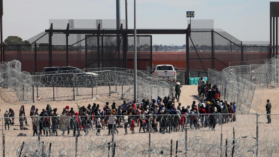 PHOTO: Migrants line up to be transferred by US Border Patrol after having crossed the Bravo River in El Paso, Texas, as seen from Ciudad Juarez, Chihuahua State, Mexico, on April 18, 2024. (Herika Martinez/AFP via Getty Images)