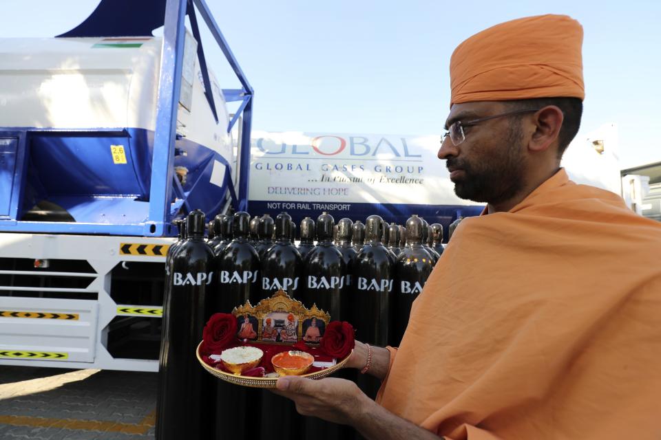 Chairman of BAPS Hindu Mandir, the main Hindu temple in Abu Dhabi, Ashok Kotecha, takes part in a blessing ceremony before shipping oxygen supplies to India, in Jebel Ali Free Zone, Dubai, United Arab Emirates, Monday, May 10, 2021. Volunteers from the country's Hindu community gathered to haul hundreds of cylinders of liquid oxygen and massive containers of compressed oxygen onto a ship bound for India. (AP Photo/Kamran Jebreili)