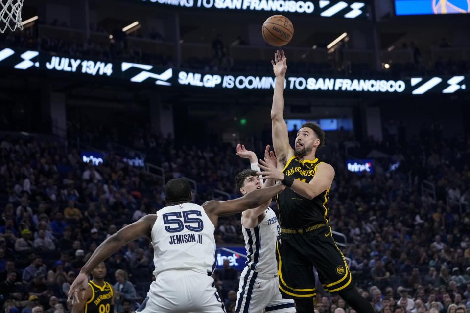 Golden State Warriors guard Klay Thompson, right, shoots over Memphis Grizzlies center Trey Jemison (55) during the first half of an NBA basketball game Wednesday, March 20, 2024, in San Francisco. (AP Photo/Godofredo A. Vásquez)