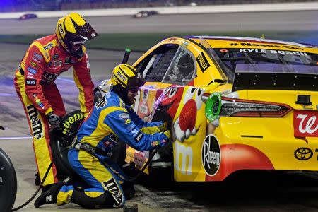 May 11, 2019; Kansas City, KS, USA; Crew members work on the car of NASCAR Cup Series driver Kyle Busch (18) during the Digital Ally 400 at Kansas Speedway. Mandatory Credit: Jasen Vinlove-USA TODAY Sports