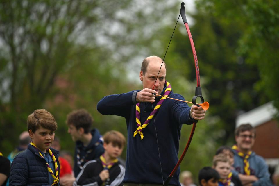 Prince William played archery as Prince George looked over his shoulder.