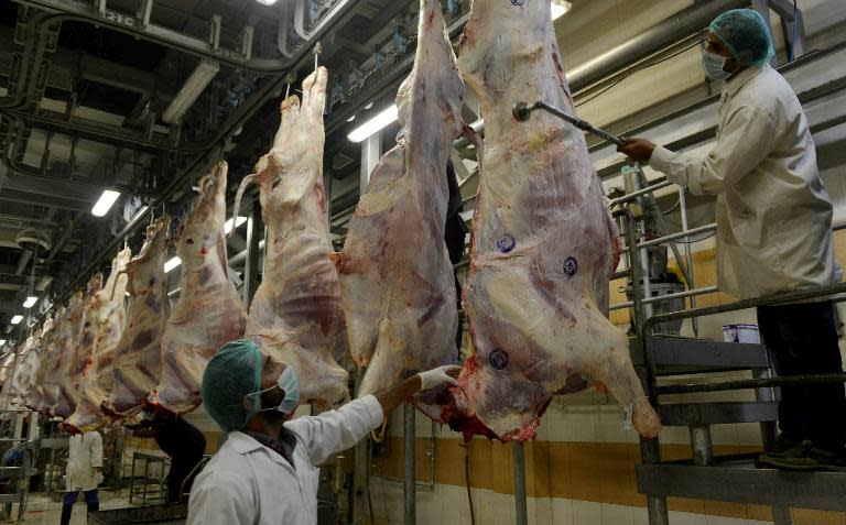 Health inspectors certify meat by placing stamps at a government slaughterhouse in Lahore