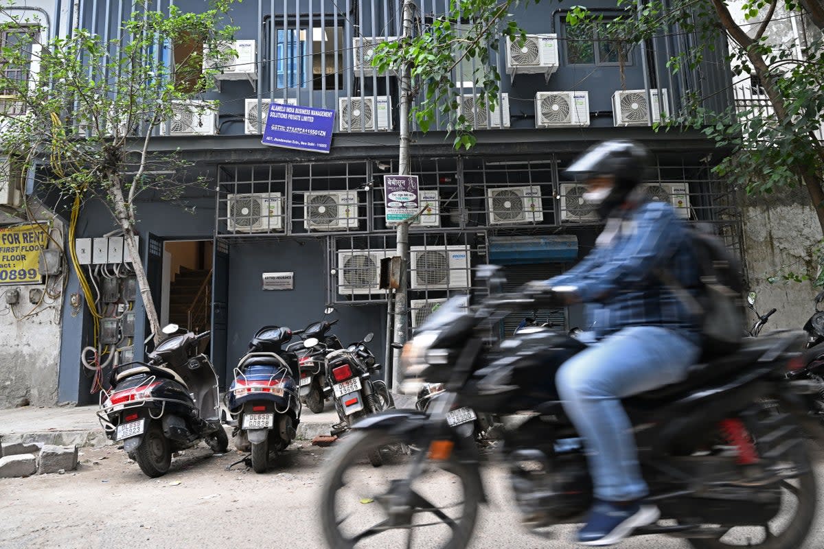 A commuter rides past a building with airconditioning units on its facade in New Delhi.  India’s electricity consumption for household air conditioners is expected to increase nine-fold by 2050 (AFP via Getty Images)