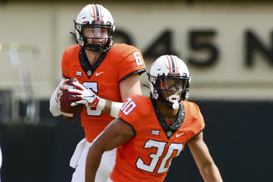 Oklahoma State quarterback Ethan Bullock (6) looks past teammate Chuba Hubbard (30) for an open receiver in the first half of an NCAA college football game against Tulsa, Saturday, Sept. 19, 2020, in Stillwater, Okla. (AP Photo/Brody Schmidt)