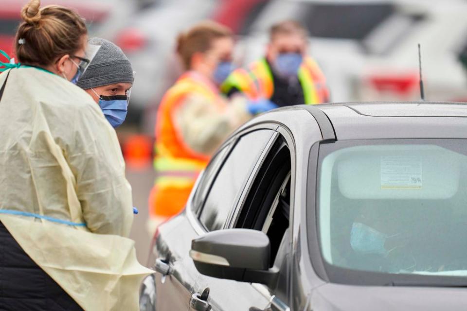 Health care workers speak with patients at a drive-thru COVID-19 assessment centre in London, Ontario. (Photo by Geoff Robins / AFP) (Photo by GEOFF ROBINS/AFP via Getty Images)