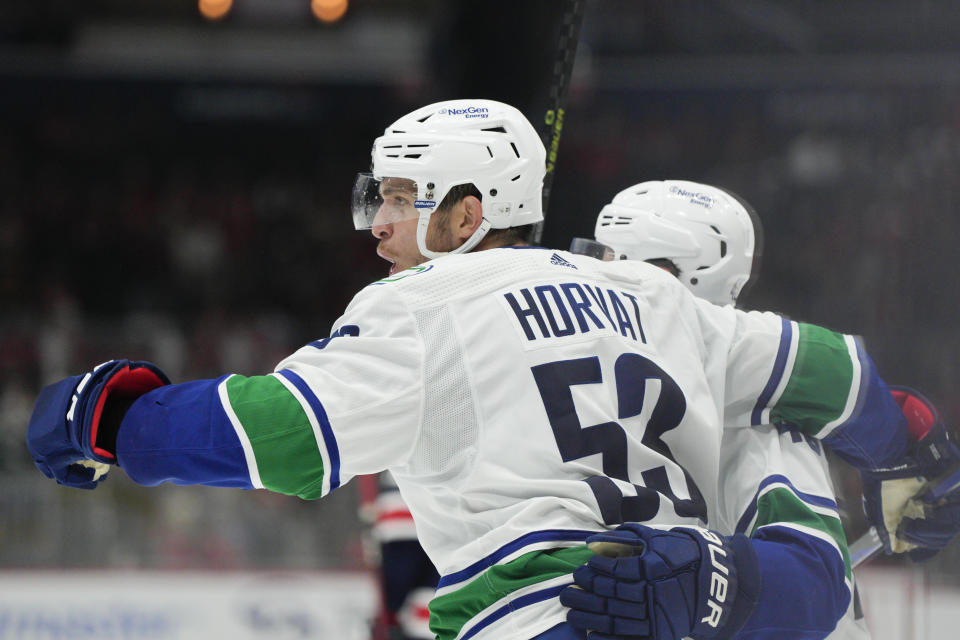 Vancouver Canucks center Bo Horvat (53) celebrates his goal with defenseman Quinn Hughes (43) during the second period of an NHL hockey game against the Washington Capitals, Monday, Oct. 17, 2022, in Washington. (AP Photo/Jess Rapfogel)