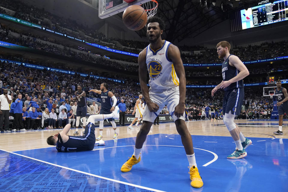 Golden State Warriors forward Andrew Wiggins (22) celebrates after dunking the ball over Dallas Mavericks guard Luka Doncic, left, during the second half of Game 3 of the NBA basketball playoffs Western Conference finals, Sunday, May 22, 2022, in Dallas. (AP Photo/Tony Gutierrez)