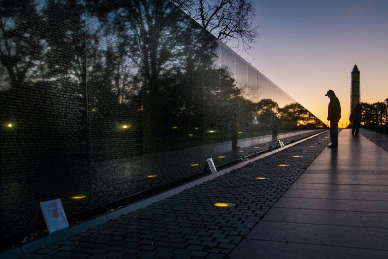 A visitor pauses at the Vietnam War Memorial in Washington, D.C. AP Photo/J. David Ake, File