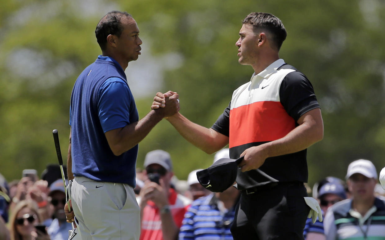 Tiger Woods, left, and Brooks Koepka shake hands after finishing the first round of the PGA Championship on Thursday at Bethpage Black in New York.