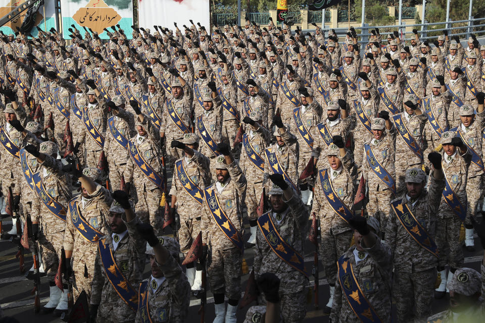 In this photo released by the official website of the office of the Iranian Presidency, Revolutionary Guard troops chant slogans at a military parade marking 39th anniversary of outset of Iran-Iraq war, in front of the shrine of the late revolutionary founder Ayatollah Khomeini, just outside Tehran, Iran, Sunday, Sept. 22, 2019. (Iranian Presidency Office via AP)