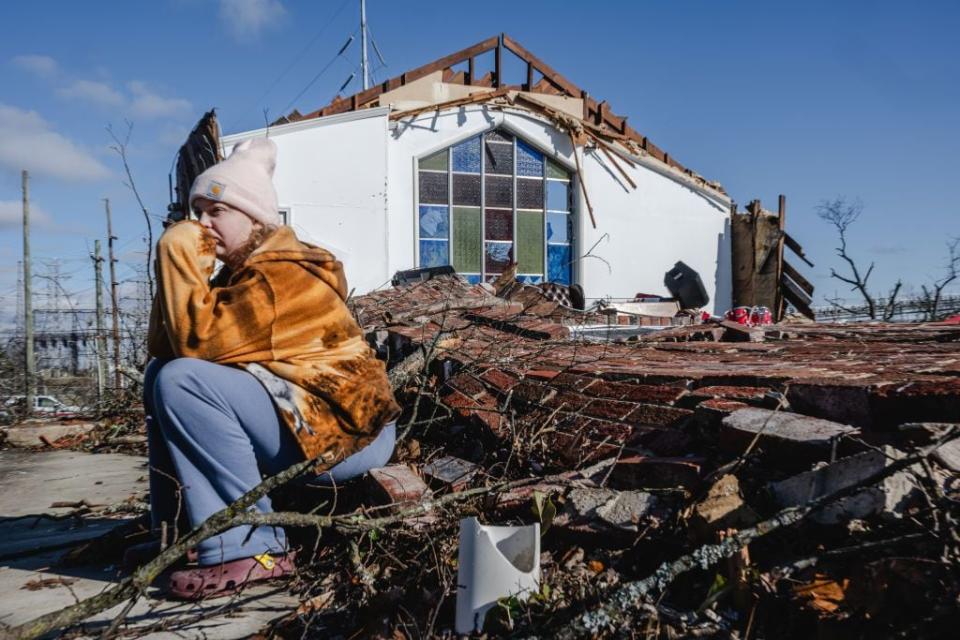 A youth sits on the collapsed wall of Sabbath Day Church of God in Christ in the aftermath of a tornado on Dec. 10, 2023, in Madison, Tennessee.