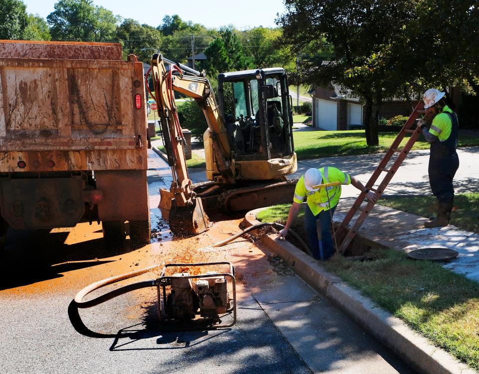 An Edmond field services worker uses a portable pump to pull water away from a broken water line on Oct. 16. The line failed under the street, they learned.