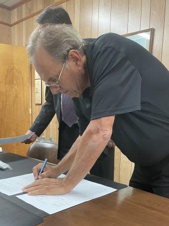 Steve Ducote signs papers after he and Missy were granted full custody of Megan's two sons. / Credit: Ducote Family