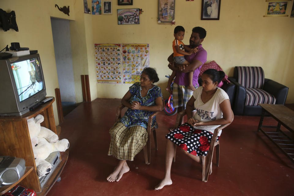 A Sri Lankan Christian catholic family watches and prays inside their home watching live transmission of Sri Lankan Archbishop Cardinal Malcolm Ranjith, in Negombo, Sri Lanka, Sunday, April 28, 2019. Sri Lanka's Catholics celebrated Sunday Mass in their homes by a televised broadcast as churches across the island nation shut over fears of militant attacks, a week after the Islamic State-claimed Easter suicide bombings killed over 250 people. (AP Photo/Manish Swarup)