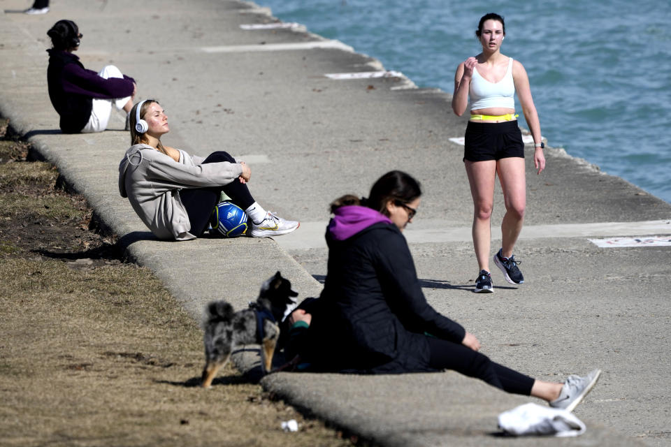 Pedestrians take in the warmer than normal temperatures near the North Avenue Beach Pier along Lake Michigan Monday, Feb. 26, 2024, in Chicago. A warm front is sweeping spring-like weather across a large swath of the country in what is usually one of the coldest months of the year. The rare warmup is sending people out of their homes to enjoy the winter respite but also bringing increased wildfire danger. (AP Photo/Charles Rex Arbogast)