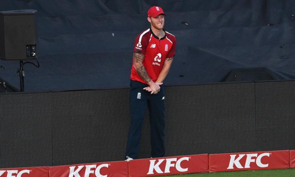 Ben Stokes winces after hurting his hand fielding on the boundary perimeter advertising boards.