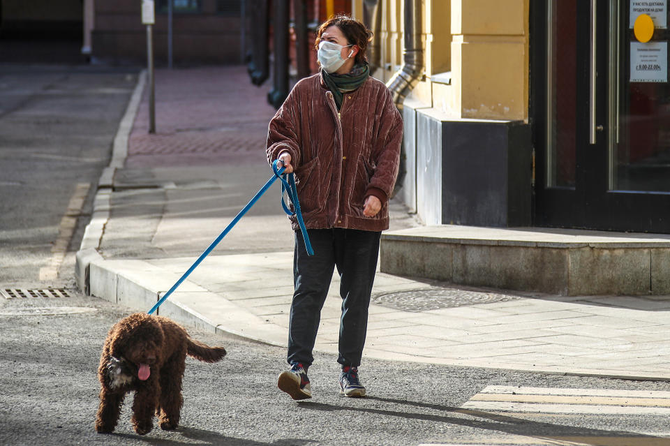 MOSCOW, RUSSIA - APRIL 6, 2020: A woman in a face mask walks her dog during the pandemic of the novel coronavirus (COVID-19). Muscovites are told not to leave home except for essential purposes. As of 6 April 2020, Russia has reported more than 6,300 confirmed cases of the novel coronavirus, with more than 4,400 confirmed cases in Moscow. Since 30 March 2020, Moscow has been on lockdown in connection with the pandemic. The Russian government announced a paid period off work for employed people and school holidays, which is expected to last till the end of April. Valery Sharifulin/TASS (Photo by Valery Sharifulin\TASS via Getty Images)