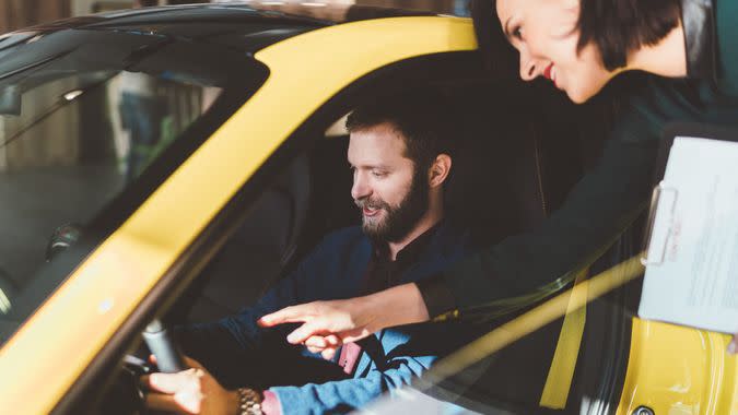 Businessman in the showroom enjoying a car.