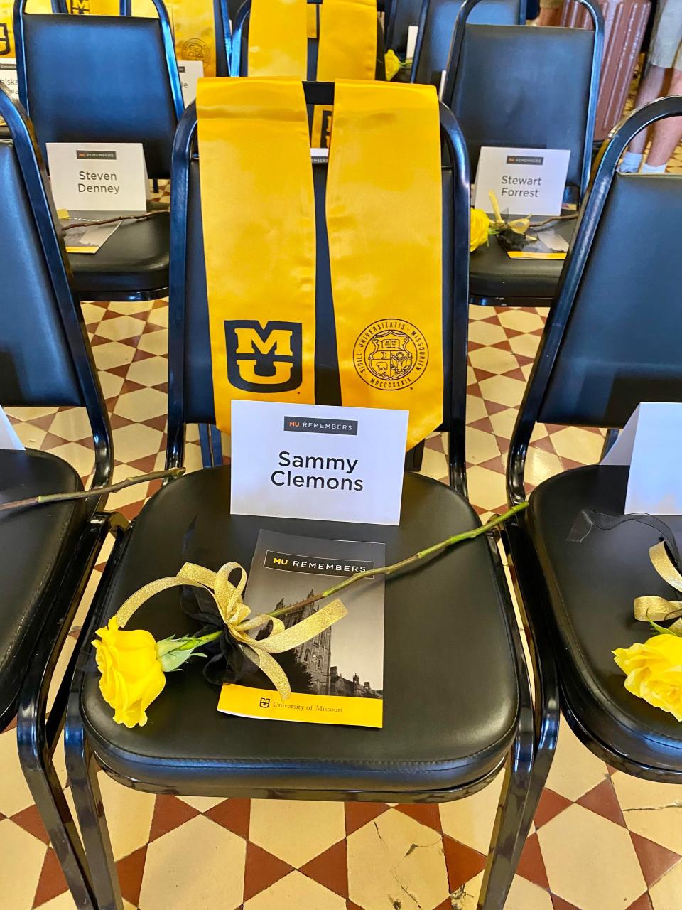 A seat is reserved for the late Sammy Clemons with graduation sash, yellow flower and name place at the MU Remembers memorial ceremony on April 14, 2023, in Columbia, Mo.