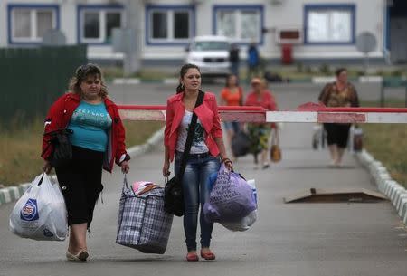 Ukrainian refugees walk from Ukraine into Russia at border crossing point Donetsk, in Russia's Rostov Region, August 19, 2014. REUTERS/Alexander Demianchuk/Files