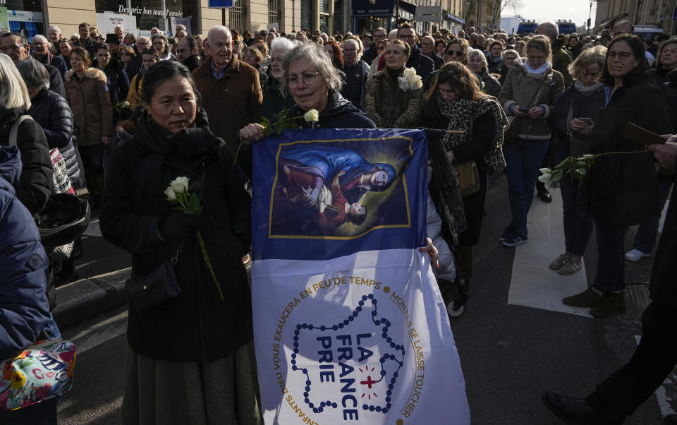 An anti-abortion activist holds a flag depicting the Virgin Mary that reads 'France is praying" near the Palace of Versailles during the Congress session of both Houses of Parliament in Versailles, west of Paris, Monday, March 4, 2024. French lawmakers gather at the Palace of Versailles for a historic vote that will make abortion a constitutional right. (AP Photo/Michel Euler)