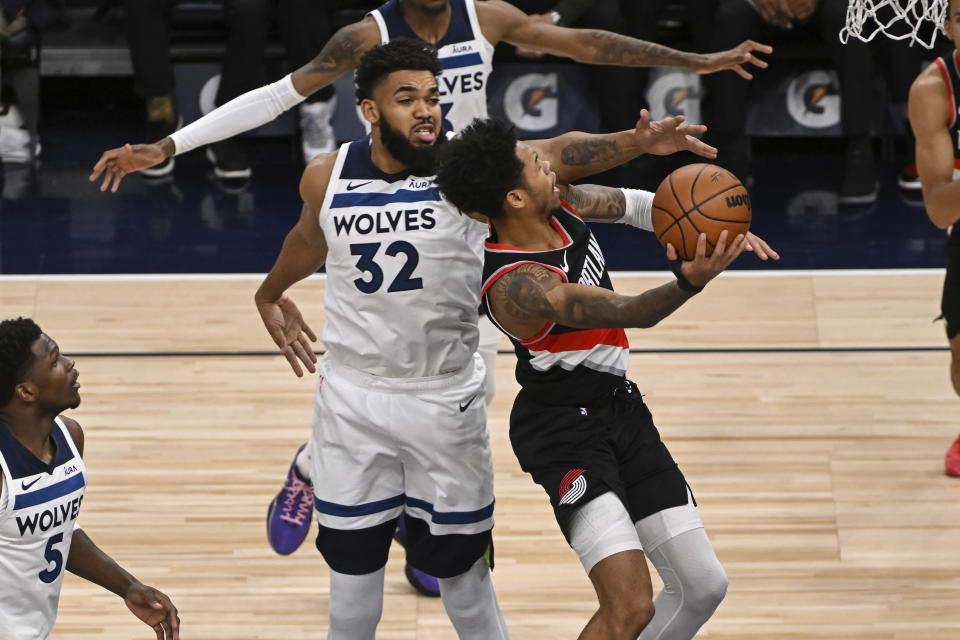 Minnesota Timberwolves center Karl-Anthony Towns (32) tries to block a shot by Portland Trail Blazers guard Anfernee Simons, right, during the second half of an NBA basketball game Friday, Jan. 12, 2024, in Minneapolis. (AP Photo/Craig Lassig)