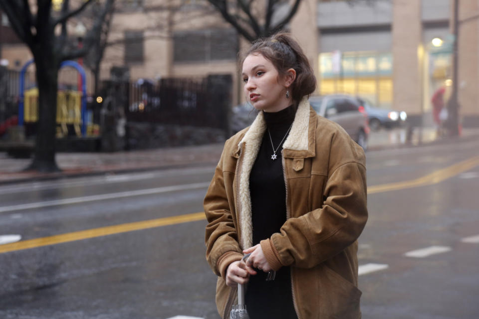 In this Dec. 30, 2019, photo, Shoshana Blum, a 20-year-old junior at City College of New York, waits for a taxi in New York. Despite having been victim to a verbal and physical anti-Semitic attack on the subway, Blum wears her Star of David pendant, a visible marker of her Jewish identity, proudly. (AP Photo/Emily Leshner)