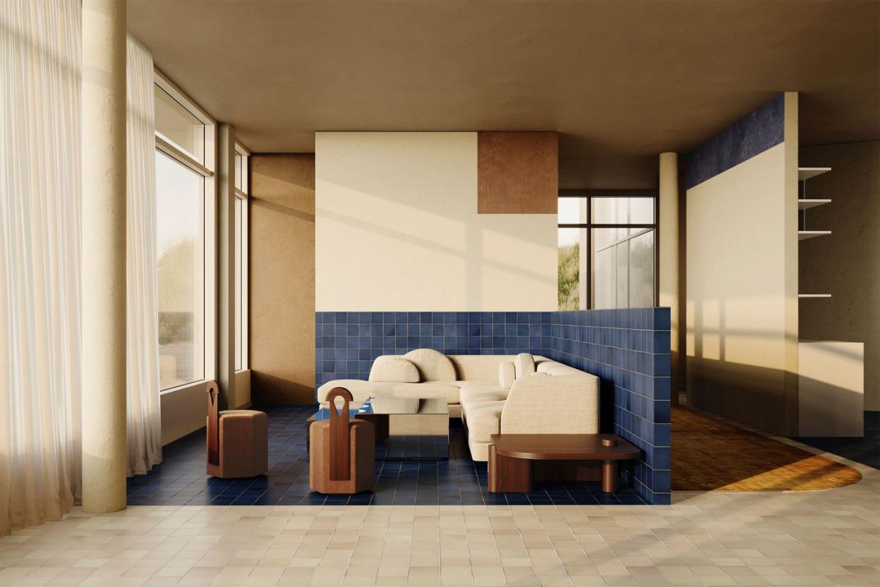a living room with an l shaped blue tile wall and partial floor with a pale white sofa in front and segmented wooded tables and side tables