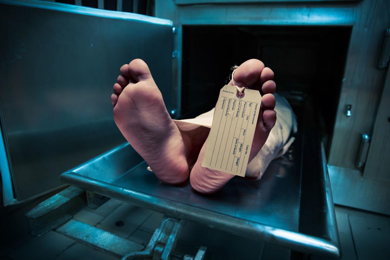 Grungy photo of feet with toe tag on a morgue table