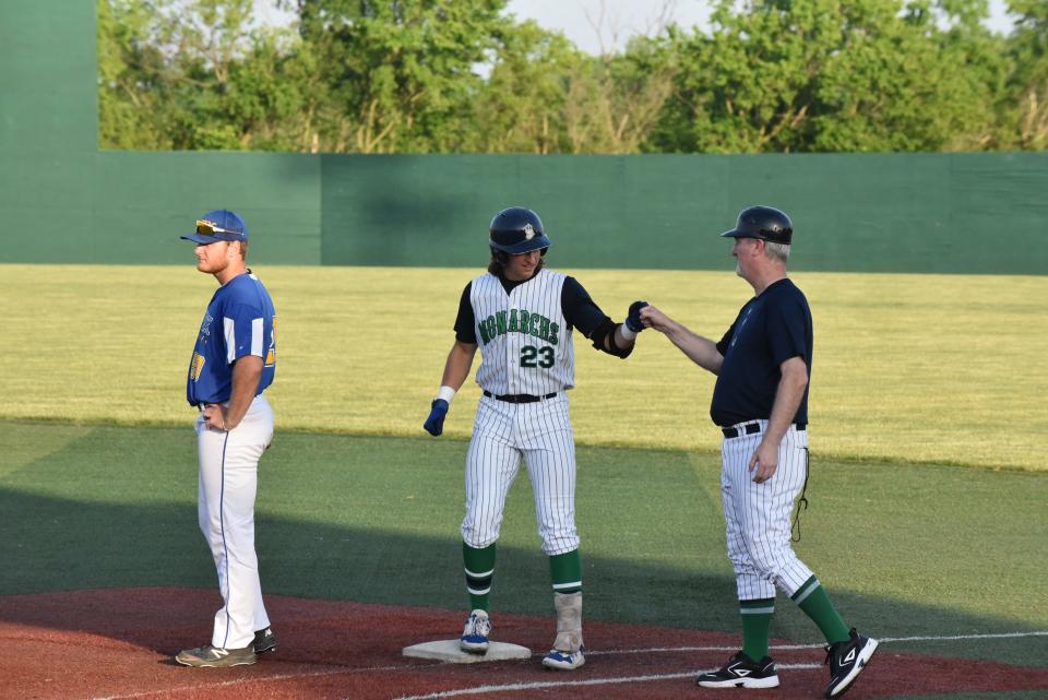 Monarchs' Henry Brown is greeted at first base by the first base coach during a game against Jet Box at Siena Heights University.