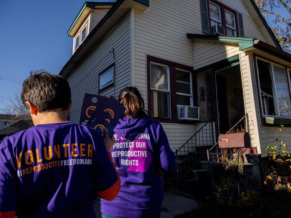 Sandra Bucciero and her son Luke approach a residence while canvassing for Proposal 3 on November 6, 2022 in Dearborn, Michigan.