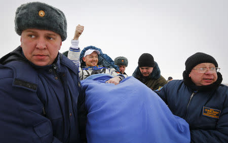 Ground personnel carry International Space Station (ISS) crew member Alexander Gerst of Germany (C) shortly after landing near the town of Arkalyk in northern Kazakhstan November 10, 2014. REUTERS/Shamil Zhumatov