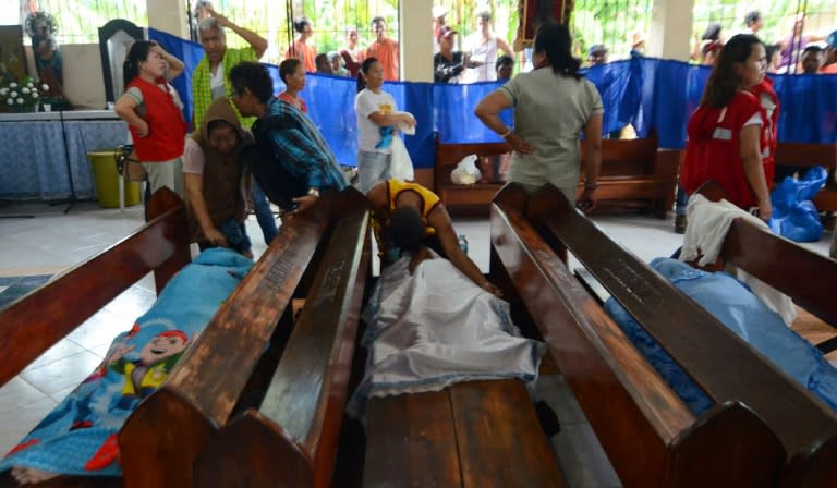 People weep next to the bodies of victims of a landslide in Naga City, on the popular tourist island of Cebu