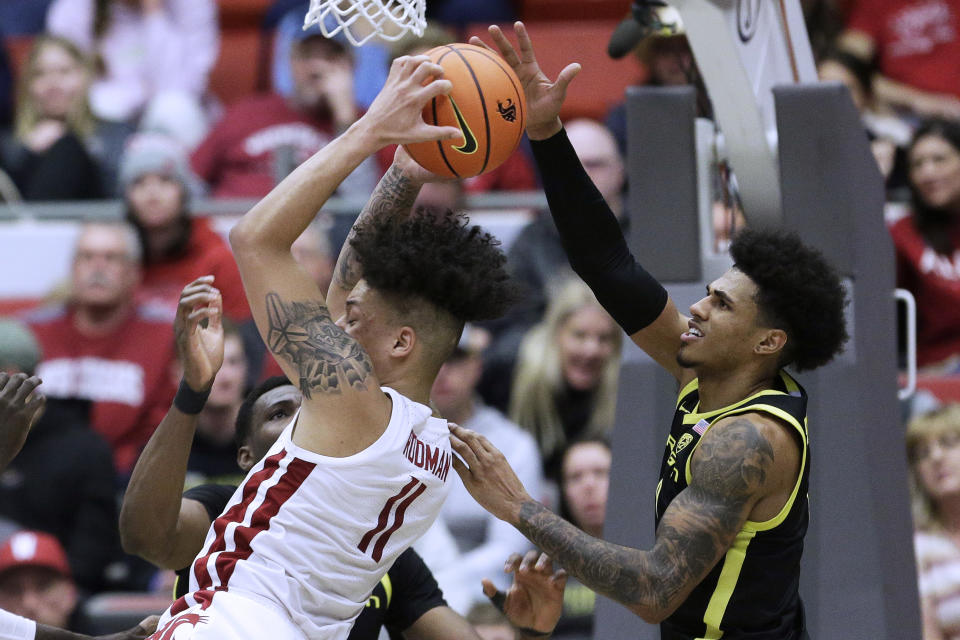 Washington State forward DJ Rodman (11) grabs a rebound next to Oregon guard Rivaldo Soares during the second half of an NCAA college basketball game Sunday, Feb. 19, 2023, in Pullman, Wash. Washington State won 68-65. (AP Photo/Young Kwak)