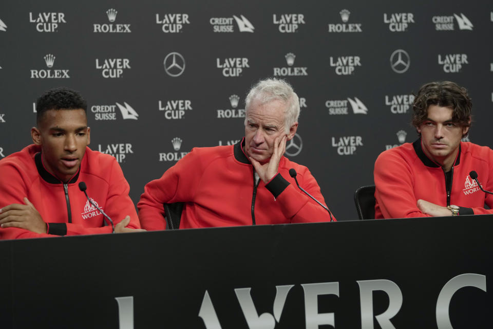From left, Felix Auger-Aliassime, of Canada, captain John McEnroe and USA's Taylor Fritz attend a press conference ahead of the Laver Cup tennis tournament at the O2 in London, Thursday, Sept. 22, 2022. (AP Photo/Kin Cheung)