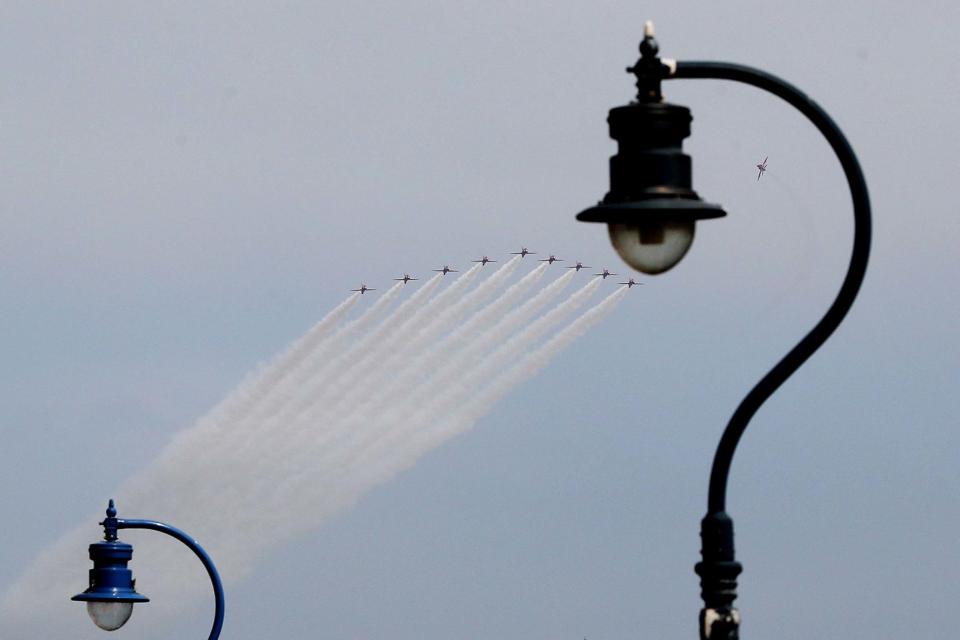 The planes left their smoke in their wake as they soared over the Titanic slipway (PA)