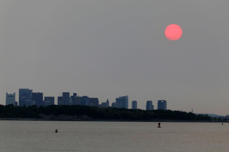 The Boston skyline is pictured shrouded in smoke as the sun sets, in Boston, Massachusetts on June 6, 2023. Smoke from the hundreds of wildfires blazing in eastern Canada has drifted south. Hundreds of wildfires were burning in Canada on June 6, 2023, according to the Canadian Interagency Forest Fire Centre, as fires have broken out across the country in recent weeks. Quebec alone had more than 150 active blazes across the province, the fire agency said.