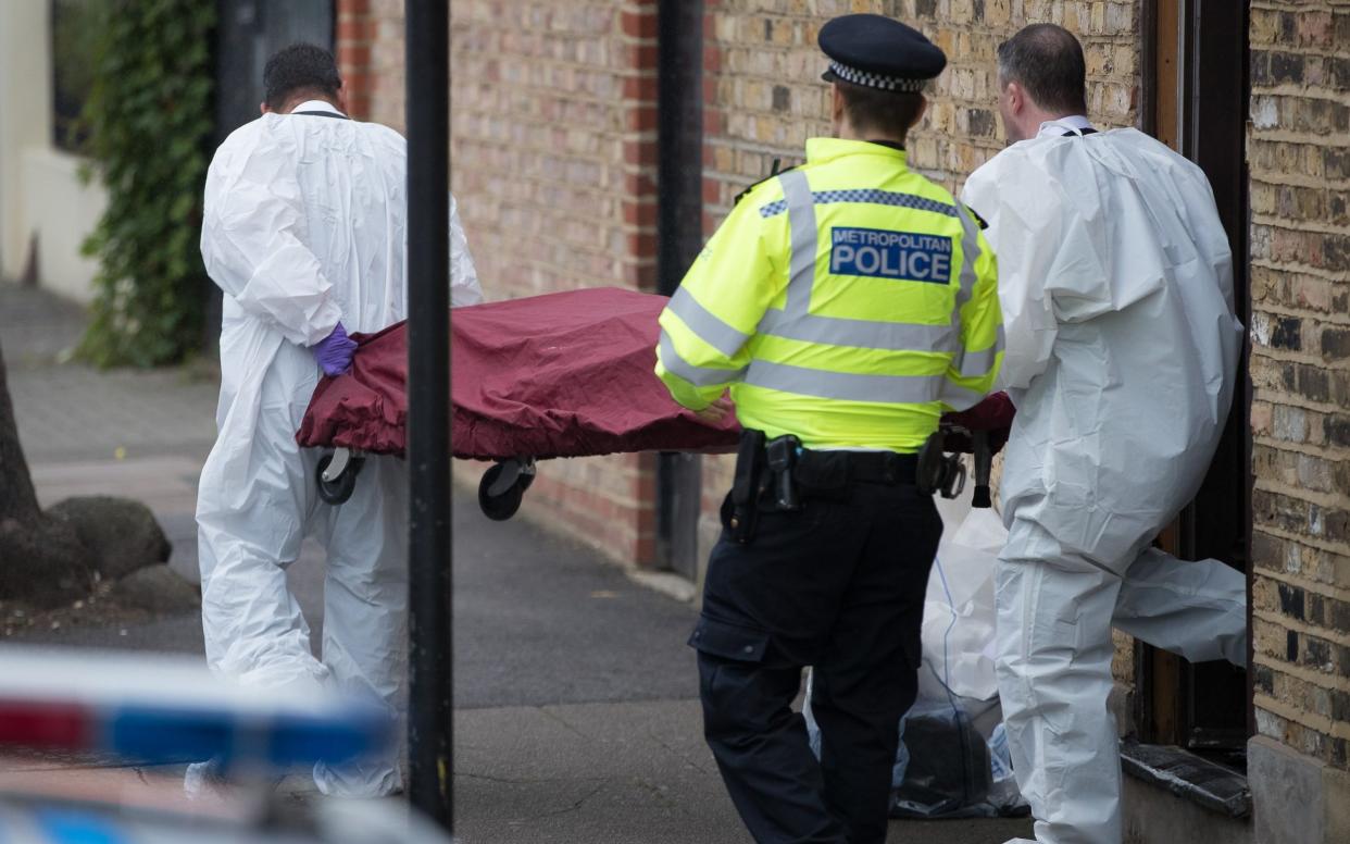 A body is removed on a stretcher from a house where police and the fire brigade attended  - London News Pictures Ltd