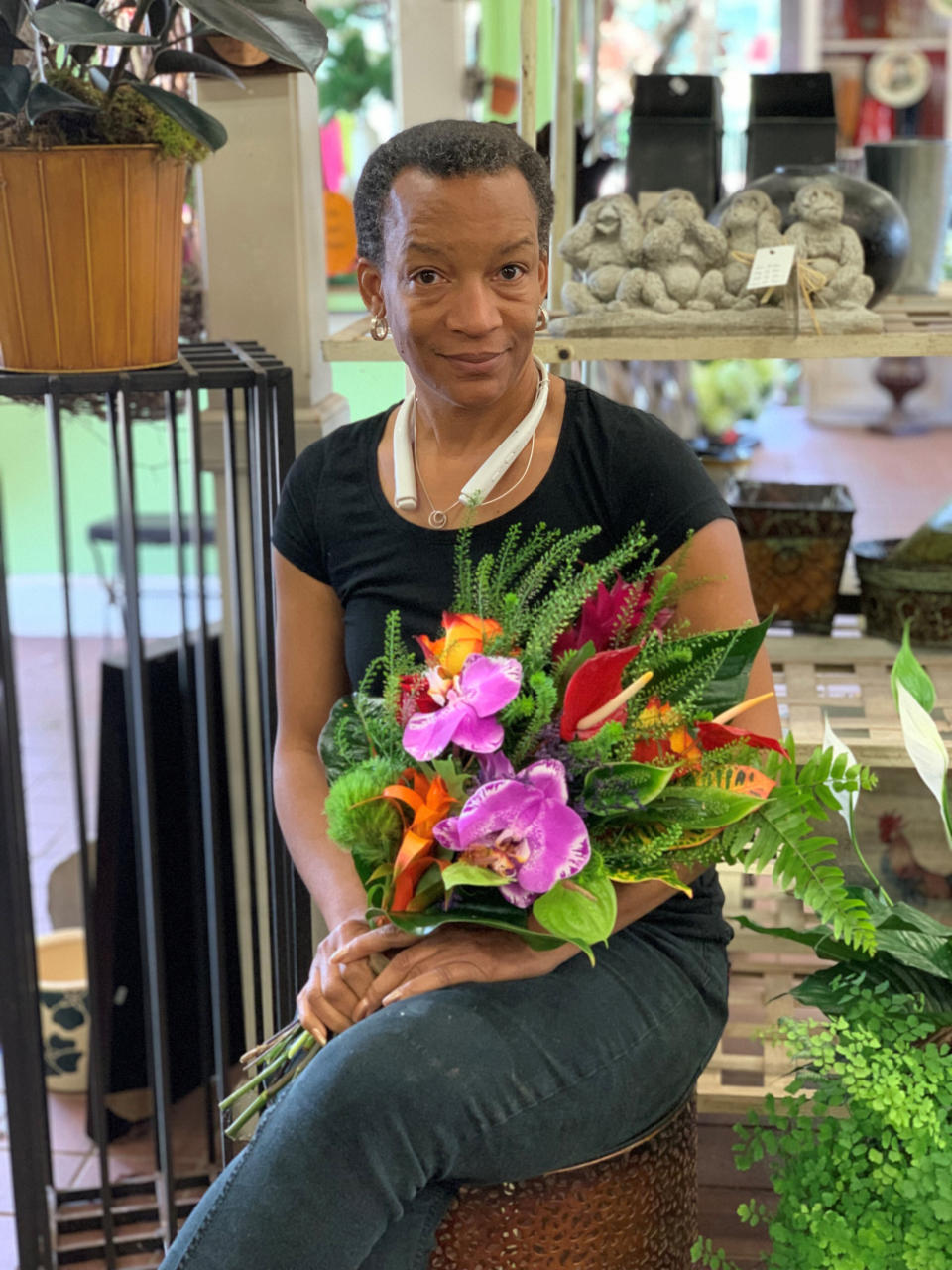 In this May 31, 2019, photo provided by Angie Morton, Lisa Taylor poses with a flower arrangement taken at Rachel’s Flowers in Memphis, Tenn. An emergency management official in Shelby County, Tenn., said Taylor was found dead Saturday, Dec. 11, 2021, after a tree uprooted in a violent storm fell through the roof of her Memphis home, landing on Taylor as she slept. Co-workers said she recently left her job as a florist of 14 years for a government job at the Memphis airport. (Angie Morton via AP)