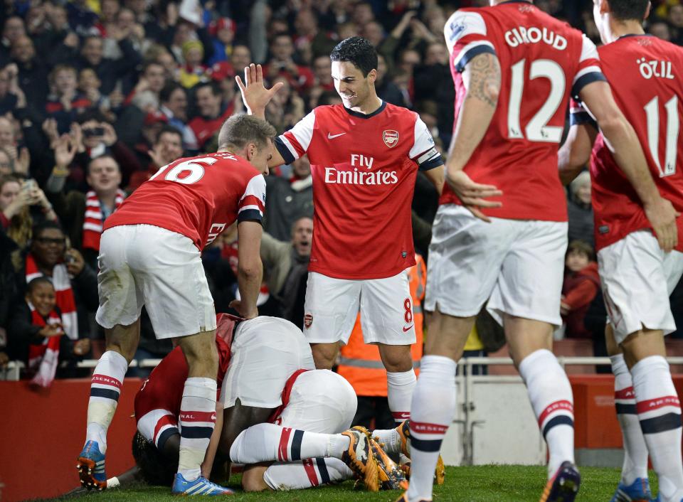 Arsenal's Cazorla celebrates with team-mates after scoring a goal against Liverpool during their English Premier League soccer match in London