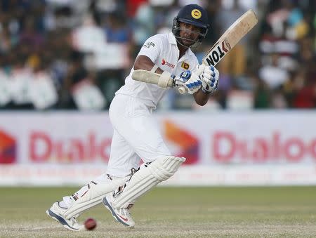 Sri Lanka's Kumar Sangakkara hits a boundary during the fourth day of their second test cricket match against India in Colombo August 23, 2015. REUTERS/Dinuka Liyanawatte