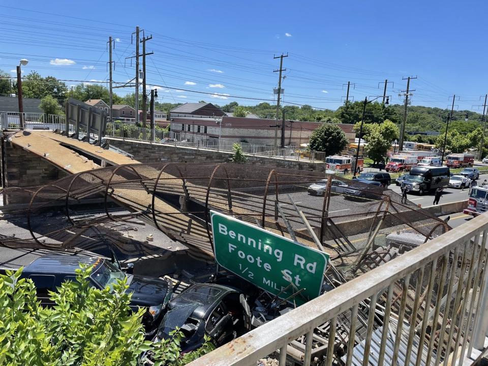 Two vehicles lay underneath a pedestrian bridge that collapsed on an interstate in northeast Washington D.C. Wednesday. The cause of the collapse is under investigation.