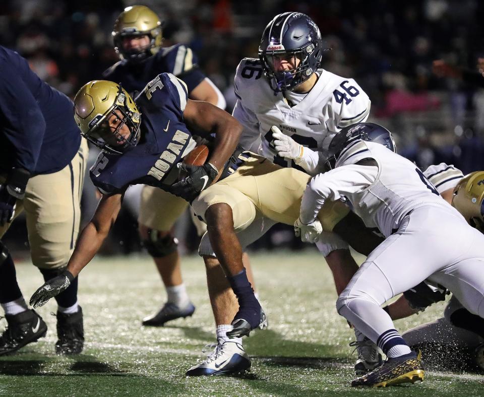 Hoban running back Lamar Sperling dives into the end zone for a first-half TD between Hudson linebacker Noah Batcher, center, and defensive back Ian Ludewig during the Division II regional final, Friday, Nov. 18, 2022, in Twinsburg.