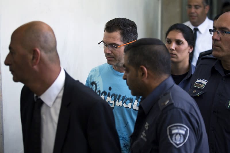 Ziv Orenstein (C), who is accused by U.S. authorities of engaging in a stock manipulation scheme involving U.S. penny stocks, arrives at a courtroom at the Jerusalem Magistrates Court July 22, 2015. REUTERS/Amir Cohen/Files