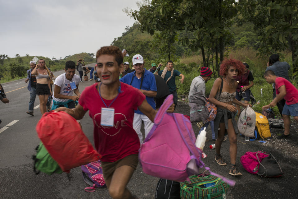 En esta foto del 2 de noviembre de 2018, miembros de un grupo de transexuales que viajan con la caravana de migrantes centroamericanos que espera llegar a Estados Unidos, corren hacia un camión que se detuvo para darles un paseo camino a Sayula, México. (AP Foto / Rodrigo Abd)