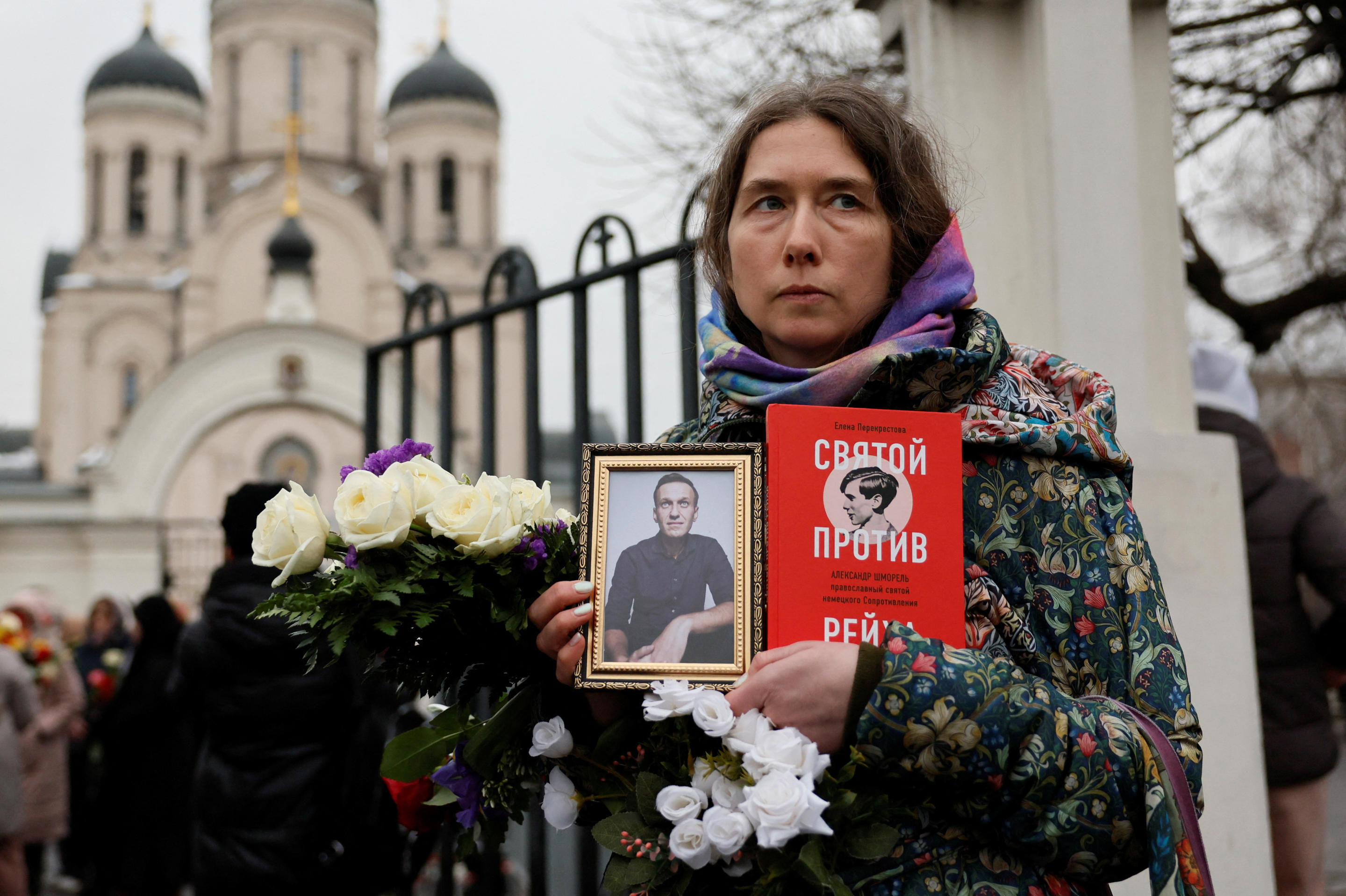 A Navalny supporter holds a framed photo of him outside his funeral in Moscow Friday.